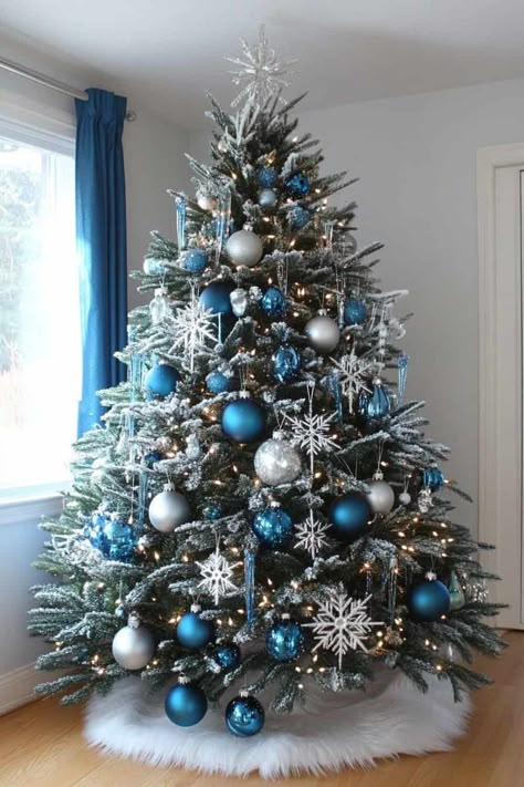 Snowflake Theme Tree, Fantasy Themed Christmas Tree, White Silver And Blue Christmas Tree, Snow Theme Christmas Tree, Winterwonder Land Christmas Tree, Christmas Decorations Blue And Silver, Snow Themed Christmas Decor, Blue And Green Christmas Tree Ideas, Blue Silver And White Christmas Tree