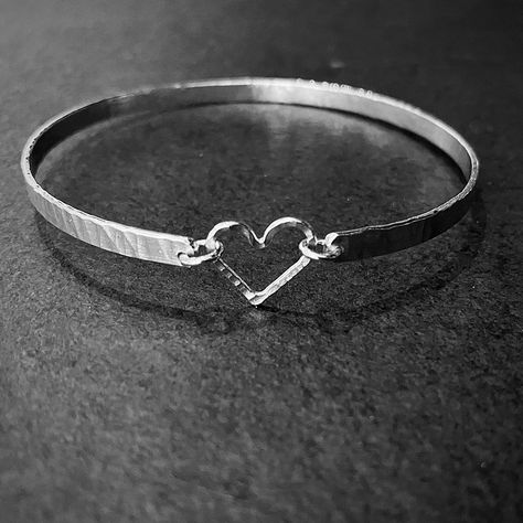 Handmade in my workshop in Fife Scotland this handmade silver bangle is simple and elegant, each bangle is unique, rolled and textured silver wire is formed and linked with an open silver heart. It is perfect for everyday wear as it is light and comfortable, it can also be worn along with other bangles from the same collection. It would make a perfect gift for a lady of any age. Comes in 3 sizes, small 6cm inside diameter, standard 6.5cm or large 7cm. Unless specified otherwise it will be made in standard size. Free gift wrapping and personalised gift card available on request Silver Heart Nails, Heart Bangle Bracelet, Fife Scotland, Sparkly Bracelets, Hammered Bangles, Handmade Silver Jewellery, Silver Bracelets For Women, The Bangles, Diy Wire Jewelry