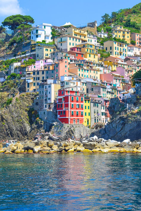 A view from the sea of the colorful village of Riomaggiore, Italy in Cinque Terre. Cinque Terre Instagram, Riomaggiore Cinque Terre Italy, Travel In Italy, Cool Backdrops, Best Greek Islands, Italy Honeymoon, Italian Riviera, Cinque Terre Italy, Seaside Village