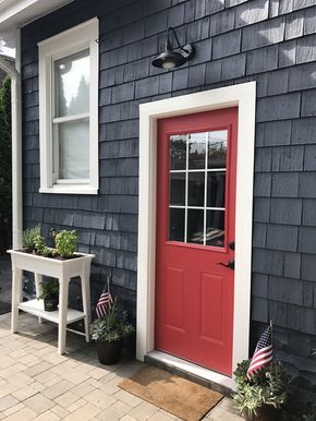 Evening dove exterior paint with Poppy front and back door | Dark navy blue and red door | Cedar shake exterior | White trim | Patriotic exterior | Standing white herb planter Turkey Habitat, Dark Blue Houses, Red Door House, Front Porch Plants, Exterior Door Colors, Door Planter, Red Front Door, Porch Plants, Gray House