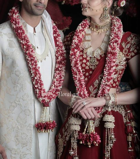 The significance of garlands in South Asian weddings lies in their symbolic representation of acceptance, love, and respect. Color Pop Wedding, Varmala Designs, Pink Bridal Lehenga, Indian Wedding Garland, Red Garland, Garland Design, Indian Bridal Sarees, Couple Wedding Dress, Different Shades Of Red