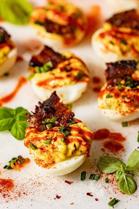 Deviled eggs with spicy sriracha drizzle, paprika, and candied bacon on top! Brunch Deviled Eggs, Cajun Deviled Eggs, Spicy Deviled Eggs Recipe, Decorated Food, Eggs Deviled, Easter Appetizers Easy, Devil Eggs, Thanksgiving Deviled Eggs, Perfect Deviled Eggs