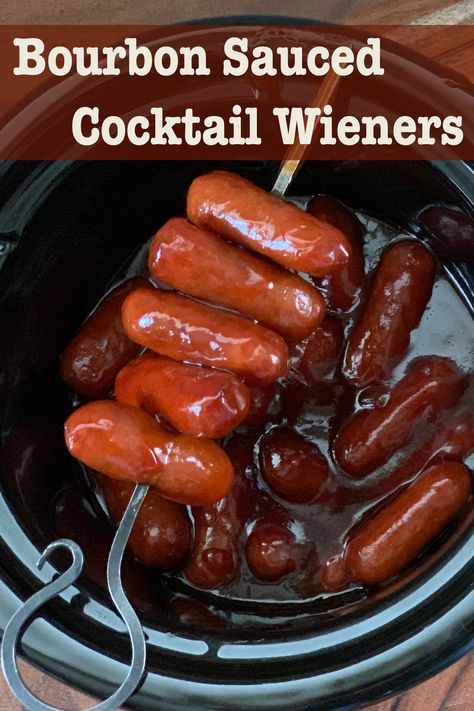 Bourbon Sauced Cocktail Wieners stacked on a skewer are balanced on top of a small crockpot filled with the hotdogs simmering in the bourbon sauce. Cocktail Sausage Recipes, Cocktail Weiners, Crockpot Party Food, Cocktail Wieners, Cocktail Weenies, Easy Make Ahead Appetizers, Cocktail Sausages, Bourbon Recipes, Bourbon Sauce