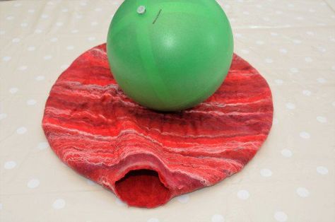 The Gertie ball laying on top of the project showing how much shrinkage still needs to take place. Wet Felting Bag On A Ball, Felt Bag On A Ball Diy, Felt Balls Ideas, Felt Vessels, Felt Pins, Felted Accessories, Wet Felting Tutorial, Felting Tutorial, Felt Wool Ball