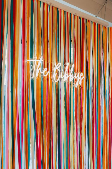 Colorful Streamer Backdrop, Colorful Event Design, Bright Wedding Decorations Diy, Ribbon Wedding Backdrop, Photo Booth With Neon Sign, Colorful Party Backdrop, Diy Wedding Backdrop Cheap Indoor, Wedding Decorations Photos, Ribbon Wall Backdrop