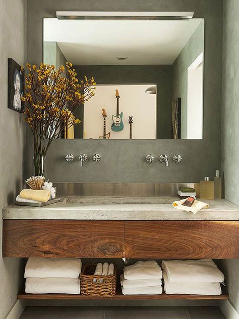 A concrete countertop and stainless-steel backsplash provide a contemporary feel to this small space. Concrete Bathroom Design, Dekorere Bad, Bilik Air, Concrete Bathroom, Bathroom Design Inspiration, Trendy Bathroom, Modern Bathroom Vanity, Bathroom Renos, Concrete Countertops