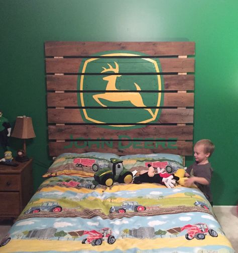 Pallet headboard with painted John Deere logo. John Deer Theme Bedroom, Tractor Headboard, John Deere Room Ideas Kids, John Deer Bedrooms, Boy Tractor Room, Pallet Wood Headboard Diy, John Deere Nursery, Painted Wood Headboard, John Deere Bedroom