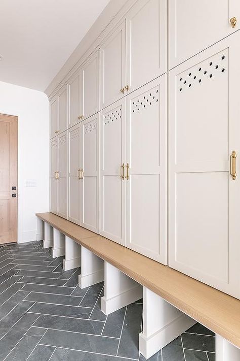 Light gray mudroom cabinets paired with brass pools transform an ordinary space into a practical and classic design. Gray Mudroom Cabinets, Gray Mudroom, Mudroom Floor, Millhaven Homes, Transitional Laundry Room, Built In Lockers, Mudroom Cabinets, Mudroom Flooring, Grey Shelves