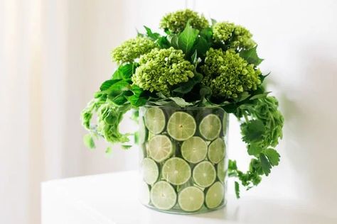 Hit the grocery store for flowers, limes, lemons or oranges to create this pro-looking centerpiece on the cheap. Diy Thanksgiving Centerpieces, Simple Centerpieces Diy, Lemon Vase, Thanksgiving Floral Arrangements, Winter Table Setting, Lemon Centerpieces, Fruit Centerpieces, Thanksgiving Entertaining, Thanksgiving Floral