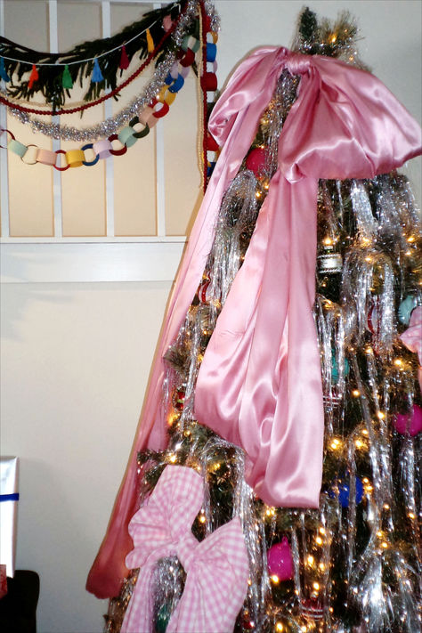 We're not saying we invented the oversized Christmas tree bow trend, but we definitely perfected it. DIY oversized satin bows and silver tinsel create the perfect whimsical retro Christmas tree. #retrochristmas #nostalgicholiday #bhg Retro Tinsel Christmas Tree, Maximalist Christmas Aesthetic, Tinsel Bow Christmas Tree, Eloise Christmas Tree, Maximalist Holiday Decor, Bows And Tinsel Christmas Tree, Bow Christmas Aesthetic, Oversized Bow Christmas Tree, Tinsel Christmas Decorations