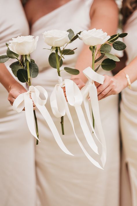 Bridesmaids in white ivory one shoulder bridesmaid dresses holding white rose single stem bouquets with white ribbon | wedding flower trends | simple and minimalist wedding flowers | Hannah Miles Photography Single Stem Flower Bridesmaid, Single Stem Bridesmaid Bouquet White, Bridesmaids Single Rose Bouquet, Single Stem Bridesmaid Flowers, Single White Rose Bridesmaid Bouquet, Bridesmaids Not Holding Flowers, Simple Peony Wedding Bouquet, One Rose Bridesmaid Bouquet, Simple Wedding Bouquets Bridesmaid