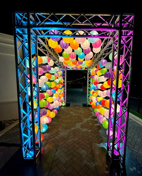 🏮🌟 Illuminated wonders await! Our custom colorful paper lantern entrance lights up the night, creating a magical welcome for this evening outdoor event.  #lantern #lanterns #paperlanterns #customdecor #customentrance #glowentrance #glow #colorfuldecor #lighting #customlighting #paperlantern #eventdecor #lanternentrance #paperlanternentrance #lanternlights #multicolor #florida #custom #brightdecor #outdoordecor Paper Lanterns Lights, Street Decoration Ideas, Small Stage Design, Festival Entrance, Neon Event, Event Entrance Design, Photo Booth Design, Event Entrance, Theme Carnaval