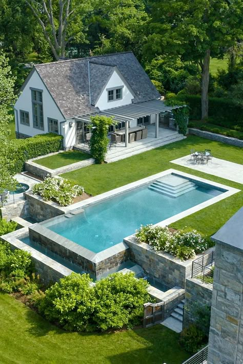 Built from scratch, this elegant estate can stand the test of time thanks to its thoughtful design and material choices. #ad - Photograph courtesy of Gault Stone & Landscape Supplies - #pool #connecticut #stone #stonehome #poolhouse #luxuryhome #luxuryhomes #homeideas #poolgoals #homedesign #homeinspiration #newengland #newenglandhome #backyard #outdoorspaces #outdoorentertaining #summertime #springtime #greenery Pool Country House, Beach Front Pool, Pool And Garden Design, Cottage Pool, Small Pool House, Country Pool, Raised Pools, Modern English Country, Stone Landscape