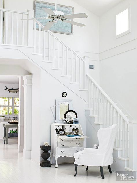 Sometimes staircases need to blend in instead of stand out. Paired with square balusters, plainly profiled handrails and posts, and a white-painted finish, this stair railing perfectly suits the breezy monochromatic color scheme. Stairway Railing Ideas, Wood Railings For Stairs, Wood Stair Treads, Modern Stair Railing, White Staircase, White Stairs, Contemporary Stairs, Staircase Railing Design, Iron Stair Railing