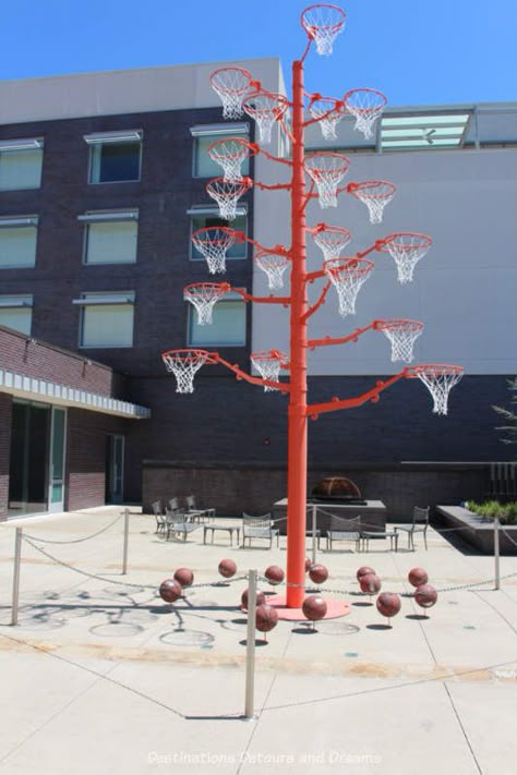 A pole with many basket hoops is an art installation outside 21c Museum Hotel in Bentonville, Arkansas Usc Basketball, Urban Art Installation, Ohio State Basketball, Indoor Basketball Hoop, Basketball Shorts Girls, Basketball Games For Kids, New York Basketball, Contemporary Art Museum, Museum Hotel