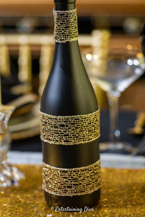 How To Decorate Wine Bottles For  Centerpieces | Best New Year's Eve Party Ideas Gold Diy Centerpieces, Decorate Wine Bottles, Spray Painted Wine Bottles, Inexpensive Centerpieces, Wine Bottle Centerpieces, Bottle Centerpieces, Unique Party Favors, Great Gatsby Party, Painted Wine Bottles