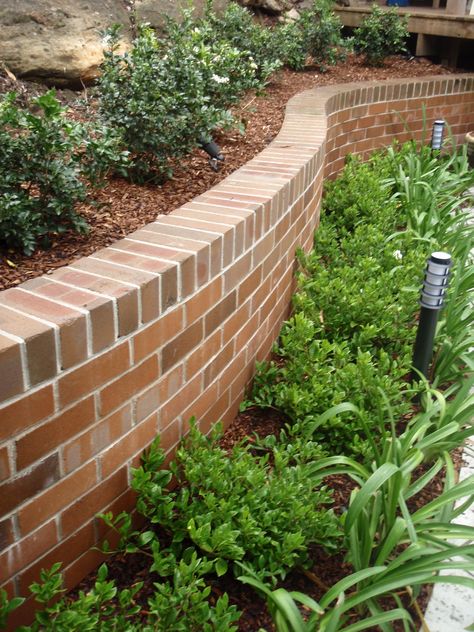 Curved brick walls with planting to soften Front Yard Brick Landscaping, Brick Retaining Walls, Brick Retaining Wall Garden, Brick Raised Garden Beds, Bricks House, Brick Flower Bed, Brick House Exterior Makeover, Brick Wall Gardens, Driveway Edging