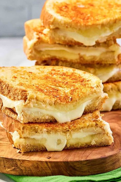 Indulge in the irresistible goodness of Starbucks Grilled Cheese Sandwich! Made with a perfect blend of sourdough bread, gooey mozzarella, and rich white cheddar cheese on the inside, and a savory butter garlic parmesan crust on the outside. This is comfort food at its finest. Get the easy copycat recipe to make the best homemade grilled cheese sandwich at home. Starbucks Grilled Cheese, Savory Butter, Crispy Grilled Cheese, Homemade Grilled Cheese, Tasty Sandwiches, Hot Sandwich Recipes, Grill Cheese, Sandwich Ideas, Tasty Dinner