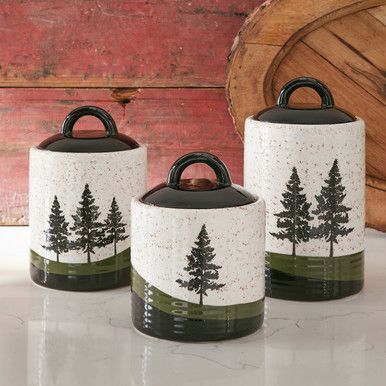 A Black Forest Decor Exclusive - Elevate your kitchen with a subtle touch of forest charm with this ceramic canister set sporting pine trees and a speckled white, green and black finish. Dishwasher safe. Medium: 5"Dia. x 5 1/4"H; Small: 5"Dia. x 4 1/2"H; Large: 5"Dia. x 7"H. Cannister Ideas Kitchen, New Home Essentials, Green Kitchen Decor, Ceramic Canister Set, Ceramic Canisters, Black Forest Decor, Log Cabin Decor, Ceramic Canister, Forest Decor