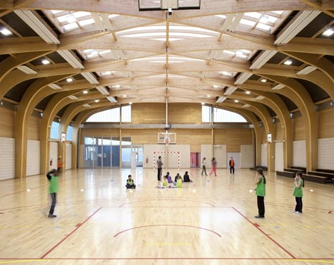 The gymnasium Regis Racine is situated in Drancy north east Paris. the program of this building includes: an indoor sports hall 22 meters long and 44 meters large, a dance hall, a space for local associations and dressing rooms for teams and referees. It was designed for pupils of schools and... Gym Architecture, Sports Facility Architecture, School Hall, Indoor Basketball Court, Timber Architecture, Paris Atelier, Timber Roof, Timber Buildings, Wood Architecture