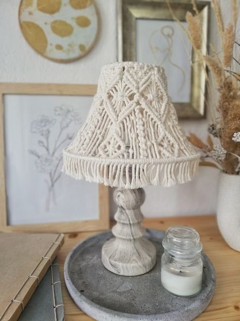 Illuminate your space with a touch of rustic charm! Our Lapsade Table Lamp, wrapped in an intricate macramé design, brings both artistry and warmth into any setting. Features: Farmhouse Elegance: Designed with the rustic charm of country style, this lamp not only brightens a room, but also adds a tasteful touch of vintage beauty. Cozy Glow: The macrame lampshade casts a unique shadow that creates a cozy and atmospheric light, perfect for evening reading, intimate dinners or just relaxing after a long day. Handcrafted Design: each knot and weave is a testament to craftsmanship, making each lamp a unique piece of art. The detailed macramé design adds texture and dimension and sets it apart from your average table lamp. Versatile Placement: Its size and design make it versatile for use as a f Macrame Lampshade, Shadow Lamp, Macrame Lamp Shade, Macrame Lamp, Decor Lamp, Fabric Gift Wrap, Macrame Design, Bedside Lamp, Vintage Beauty