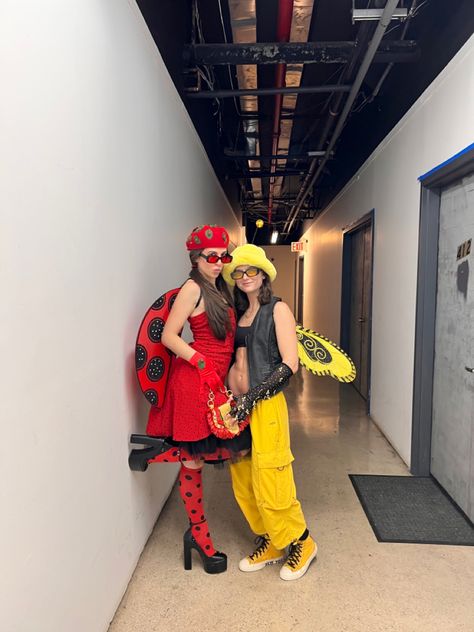 Two girls wearing Halloween costumes one girl is wearing a red polka dot dress red and black knee high polka dot socks black platform Steve Madden heels ladybug wings and a red kangol hat. Other girl is wearing yellow cargo pants yellow converse black bra black leather vest a yellow furry hat and bumble bee wings. Easy Lesbian Couple Halloween Costumes, Couples Halloween Costume Ideas For Lesbians, Ladybug And Bee Costume, Halloween Costumes For Lesbian Couple, Lesbian Couple Costumes For Halloween, Couple Halloween Costumes For Lesbians, Girl Couple Costumes, Ladybug Costume Diy, Gay Halloween Costumes Women