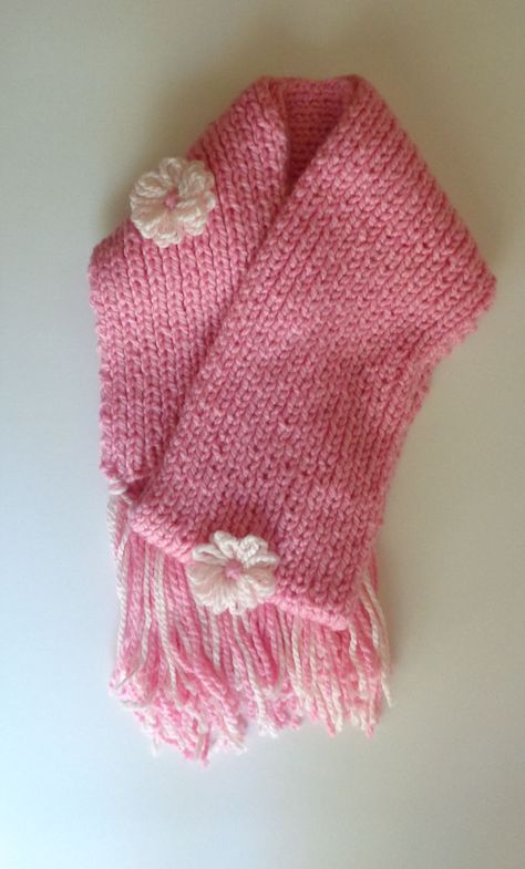 -Made with soft 100% acrylic yarn, this handknitted scarf is sure to keep any neck warm during cold weather. -With dimensions of 70" x 7", women will be encouraged to wear their scarf in any style they choose. -This scarf is adorned with three flowers in soft pink; one in the center, and two near the ends of the scarf. These flowers are also made from 100% acrylic yarn. -Tassels, the same colors as the scarf, measure about 8 inches long. Scarf With Tassels, Three Flowers, Be Encouraged, Flower Scarf, Hand Knit Scarf, Pink Scarves, Women Pink, Knitting Accessories, Neck Warmer