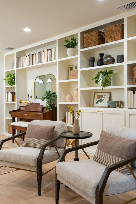 These built-in bookshelves helped created a real stand-out moment for this space. The bookshelves were built up around the piano and were a great way to display all of the personal treasures like pottery, plants, arts, and books that our client had collected over the years. It's perfect mix of personality and elegance. Click through to see the "before" of this space, and view the entire design guide for this home! ➡️ Built Ins Dining Room, Piano Living Rooms, Piano Wall, Jasmine Roth, Piano Decor, Built In Shelves Living Room, Empty Nesters, Piano Room, Mid Century Modern Living