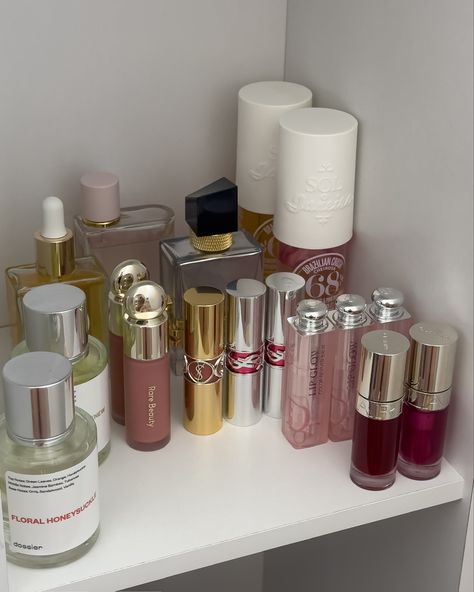 A shelfie containing neatly organized makeup products from Clarins, Rare Beauty, Yves Saint Laurent, Dior, and more. Shelf Makeup, Ysl Aesthetic, Makeup Shelf, Beauty Shelf, Makeup Favs, Makeup Shelves, Saint Laurent Makeup, Viral Makeup, Ysl Makeup