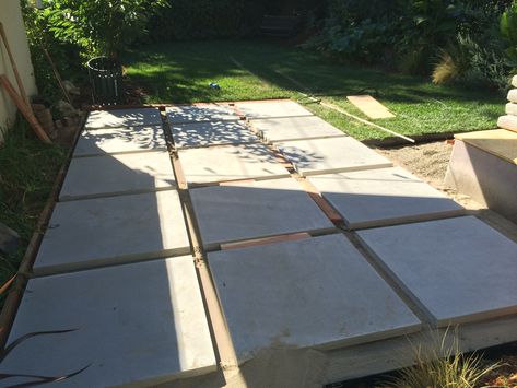 Once the 3/4” layer of sand is in we installed each of these 36”x36” precast concrete pavers. I used a 2x4 as a guide to creat even spacing between the patio pavers. It’s important to double check the level of each slab at this point. The DIY patio design is coming together! Concrete Pavers Walkway, Pavers Walkway, Outdoor Patio Pavers, Walkway Designs, Diy Patio Pavers, Outdoor Pavers, Patio Pavers Design, Patio Pavers, Paver Walkway