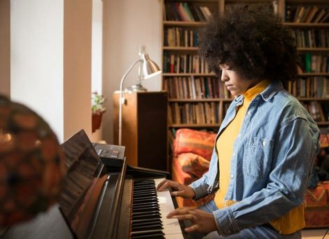 Side view of a Black woman with afro, yellow turtleneck, and denim jacket sitting in front of a bookshelf & couch. She is playing a piano Vegan Cookout, Esperanza Spalding, Vampire Love, Energy Activities, Physical Space, Survival Instinct, Girls Music, Playing Piano, Free Tips