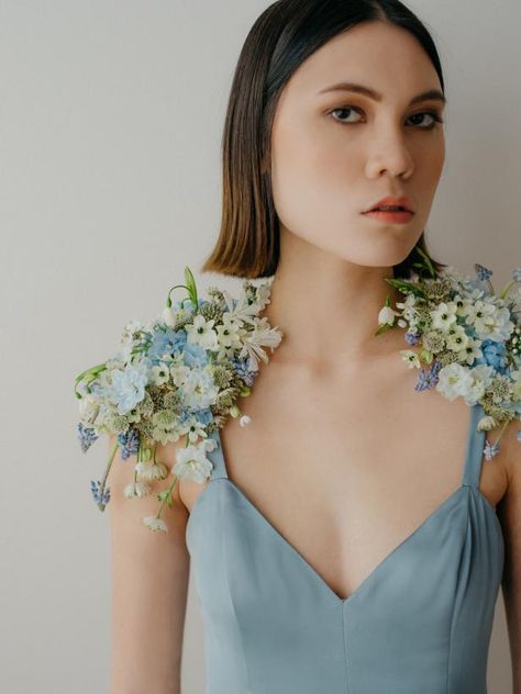 These floral epaulets were made with delphinium, allium and ornithogalum florets, as well as muscari and snowdrops. The base is made of out of faux leather and the flowers are attached with floral adhesive. Floral Attire, Flower Design Ideas, Wearable Flowers, Fairytale Bridal, Fresh Flower Jewelry, Phuket Wedding, Floral Bustier, Natural Hair Wigs, Light Blue Wedding