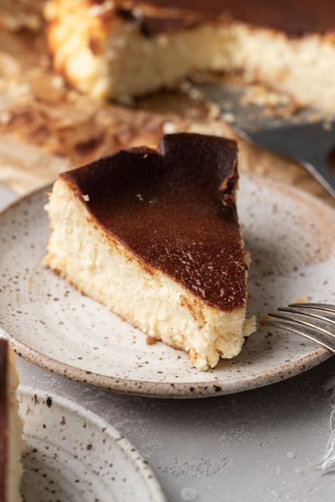 A slice of burnt Basque cheesecake on a plate. Cheesecake Basque, Crustless Cheesecake, Burnt Basque Cheesecake, Live Well Bake Often, Individual Cheesecakes, Basque Cheesecake, No Bake Pumpkin Cheesecake, Cheesecake Lovers, Homemade Cheesecake