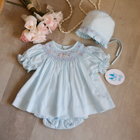 This Little Blue Bishop Dress Set Is Precious!! The Classic Smocked Neckline And Shoulders Is True To The Traditional Bishop Style Dress. A Lattice Design Embroidery Adorns The Smocking And Is Topped With Shades Of Pink, Lilac, Blue And Pale Lime Floral Bullion Details. The Short Puff Sleeves Gather With Elastic Leaving A Ruffled Hem. The Back Has A Full Button Closure Done In Lovely Matching Petite Pearlized Buttons With The "Luli" Signature Inscription. A Matching Bloomer Has An Elastic Waist Matching Embroidery, Smocked Bishop Dress, Spring Portraits, Lilac Blue, Pink Lilac, Lattice Design, Design Embroidery, Newborn Dresses, Boutique Brands