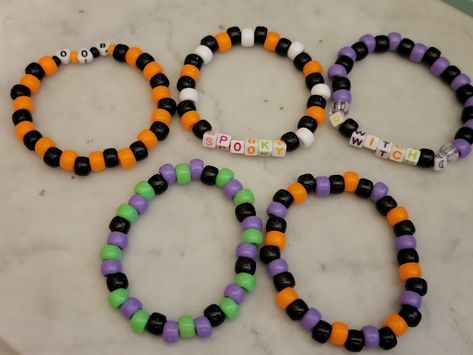 "5 different Halloween singles! All measuring around 8-8.5\" made with stretchy elastic and pony beads. Available in:  -Black and orange 'Boo' -Black and purple 'Witch' -White and orange 'Spooky' -Black, Green and Purple -Black, Orange and Purple" Pony Bead Bracelets Halloween, Bracelet Ideas Pony Beads, Halloween Bracelet Ideas, Halloween Kandi, Bracelets Fall, Halloween Things To Do, Halloween Beaded Jewelry, Safety Pin Crafts, Purple Witch