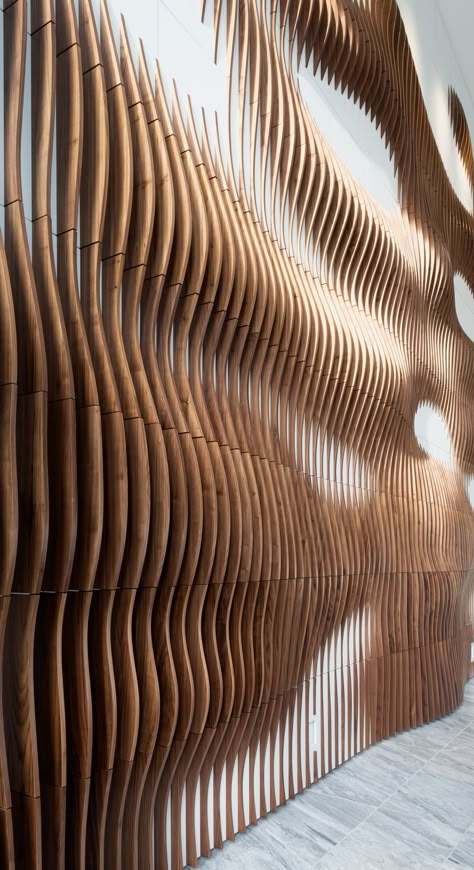 We designed, produced, and installed this parametric walnut slat wall for hte lobby of a residential development in Austin, TX.  The piece is made up of 209 wall panels and over 1500 Walnut wood slats. Walnut Slat Wall, Wood Feature Wall, Wood Facade, Wooden Facade, Interactive Walls, Wood Slat Wall, Residential Development, Parametric Architecture, Wood Cladding