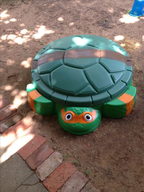 DIY Ninja Turtle Sandbox. Updated a turtle sandbox with mask and belt to turn into a Ninja Turtle. Sandbox Makeover, Diy Ninja, Cozy Coupe Makeover, Kids Sandbox, Halloween Costumes 2022, Disney Garden, Tmnt Birthday, Ninja Turtle Party, Turtle Party