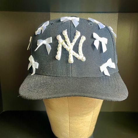 Custom Ny Yankee Hat Adorned With Pearls And Bows Coquette Vibes Colors Available: Black, Navy, Pink, Red, Brown, Grey & Tan #Coquette #Customhat #Yankeesha Custom Ny Hat, Ny Hat Outfit, Pearl Fitted Hat, Fitted Black Themed Hat, Yankee Fitted Hats, Girly Hat, Custom Hat Ideas, Customized Hats, Yankees Hat Fitted