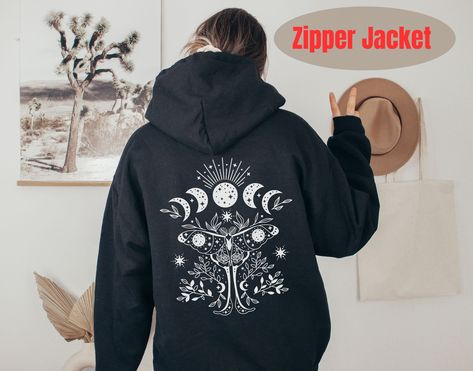 Luna Moth and Moon Phases Zipper Hoodie This Luna Moth and Moon Phases Zipper Hoodie is perfect for adding a touch of mysticism to your style. The Luna Moth is a beautiful and ethereal creature that is a symbol of transformation and rebirth. The Moon Phases design on this hoodie represents the cyclical nature of life. It is a reminder to embrace the changes that come with each phase of our lives and to find beauty in the journey. Our Luna Moth and Moon Phases Zipper Jacket is a unique and eye-catching piece that's sure to become a staple in your wardrobe. This zipped fleece jacket will keep you nice and toasty through the cold. This zipper hoodie has design on the back , has large front pockets, durable silver-colored metal zipper , and an adjustable hood with drawstring. Welcome to my sho Moth Jacket, Moth Clothing, Celestial Hoodie, Ethereal Creature, Spiritual Hoodie, Hoodie Front And Back, It's Just A Phase, Moon Hoodie, Black Zip Up Hoodie