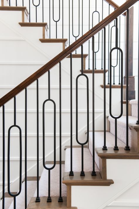 Oval iron baluster on staircase has the sleek clean lines of contemporary design with the cozy farmhouse aesthetic to create a uniquely fresh take on the country living inspired style. This look is characterized by natural textures and materials of wood mixed with satin black wrought iron to gives the warmth and simplicity. Decorating Staircase, Ms Railing, Baluster Design, Modern Farmhouse Staircase, Staircase Inspiration, سلالم حلزونية, Iron Staircase Railing, Iron Stair Balusters, Staircase Modern