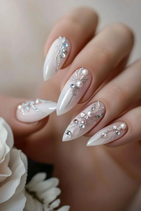 Discover over 60 stunning and sophisticated bridal nail designs perfect for 2024. From classic French tips to intricate lace patterns, these elegant designs will add the perfect finishing touch to your wedding look. Whether you prefer a subtle nude palette or dazzling sequins, there's a style here for every bride-to-be. Get inspired and find the ideal nails to complement your special day. Achieve the ultimate bridal glam with these beautiful nail art ideas! Glam Wedding Nails For Bride, Bride’s Nails, Long Wedding Nails For Bride, Wedding Nail Designs For Bride 2024, Nude Wedding Nails For Bride, Almond Nails Tips Designs, Wedding Nails For Bride Almond Shape, Unique Bridal Nails, Lace Wedding Nails