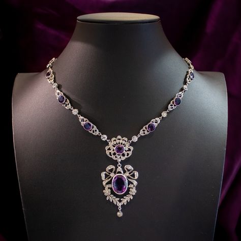 New in! A magnificent antique Edwardian paste lavaliere necklace consisting of ornate silver links leading to a spectacular open-work dropper pendant featuring pretty bow and floral motifs. Each link is bezel set with a large purple paste and accompanied by smaller clear pastes that together simulate amethysts and diamonds. The antique necklace dates to the early 1900s and has remained in excellent condition. It’s held by a safety chain and a flower-shaped box clasp at the end topped with f... Antique Necklace Victorian, Paste Jewelry, Flint Glass, Edwardian Engagement Ring, Dr Closet, Princess Jewelry, Edwardian Jewelry, Oc Inspo, Purple Jewelry