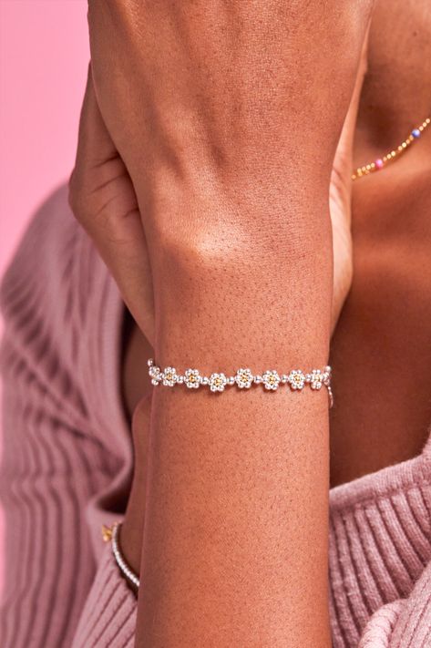 Keep blooming with our Daisy Chain Amelia Bracelet. Inspired by our bestselling daisy pieces, a daisy chain is shaped with a mix of silver and gold plated beads. This is a piece you will never want to take off and is also the perfect gift to give to a friend. Read more about our care guidelines here. Details The bracelet measures at approximately 8-25cm long on an adjustable slider chain. Daisy Chain Bracelet, Daisy Jewellery, Lipstick Nails, Bracelet Inspired, Sock Booties, Daisy Bracelet, Saltwater Sandals, Beads Bracelet Design, Sneaker Slippers