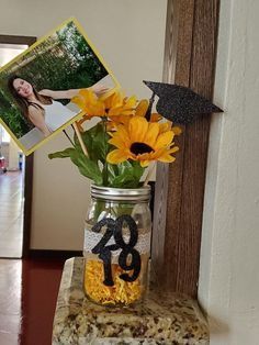 30 DIY Graduation Centerpieces That Are Easy, Cute, and Cheap Sunflower Graduation Centerpieces, Graduation Centerpiece Mason Jar Ideas, Graduation Party Ideas Sunflowers, Graduation Sunflower Theme, Diy College Graduation Decorations, Red And Yellow Graduation Party Ideas, Sunflower Grad Party, Open House Centerpieces Grad Parties, Sunflower Graduation Party Ideas