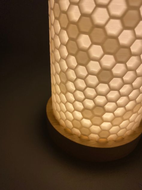 "This simple but elegant desk lamp is inspired by the natural hex pattern of the honeycomb. The subtle addition of darker hexes adds flair and elegance. The soft light will accent any desk or surface and compliments a modern theme. - available in 4\" and 6\" wide sizes - 3D printed from PLA plastic - The light source is an energy efficient LED, and is USB powered. - Includes a block to use in any standard outlet. - lamp is approx. 7\" tall" Elegant Desk, Wood Lamp Design, Modern Desk Lamp, 3d Lamp, 3d Printed Objects, 3dprinting Design, Print Ideas, Honeycomb Pattern, Wood Lamps