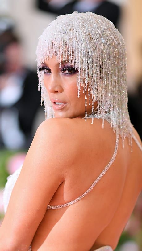 Jennifer Lopez This dazzling beaded headpiece has Cher tribute written all over it. JLo nails the look, pairing her jewelled strands with ’70s-style purple eye makeup. #JenniferLopez #Makeup #Hair #MetGala Gatsby Headpiece, Beaded Headpiece, Gala Outfit, Met Gala Red Carpet, Bride Headpiece, Glam Squad, Gala Dresses, Metallic Dress, Red Carpet Looks