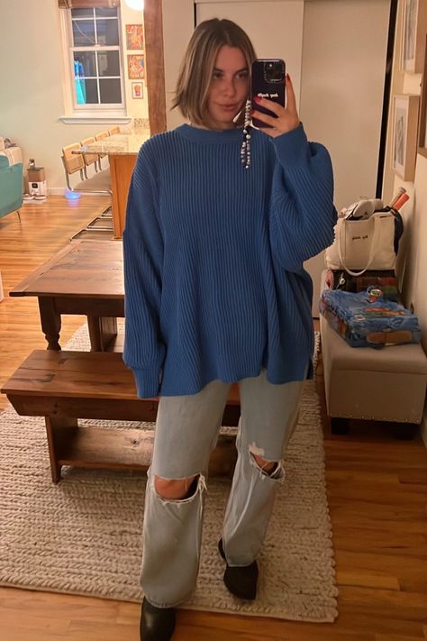 The person is wearing a blue oversized sweater, ripped jeans, and black shoes. Periwinkle Sweater Outfit, Winter Picnic Outfit, Lazy Sunday Outfit, Picnic Outfit Ideas, Picnic Attire, Periwinkle Sweater, Winter Picnic, Picnic Outfit, Oversized Black Sweater