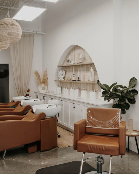 In a Bohemian, Coastal fused interior designed salon space stands caramel-colored shampoo systems. Boho Theme Hair Salon, Open Color Bar Salon, Hair Salon Minimalist, Scandinavian Hair Salon Interior Design, Costal Hair Salon, Hair Salon Bathroom, Coastal Salon, Salon Suite Layout, Boutique Hair Salon