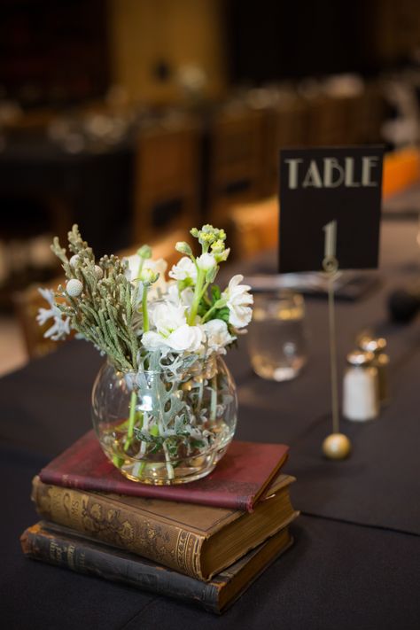 Centerpiece With Books And Flowers, Academic Centerpieces, Old Book Centerpieces, Old Books Wedding Decor, Antique Book Centerpieces, Nerdy Centerpieces, Book Centerpiece Wedding, Centerpieces With Books, Book Centerpiece Ideas