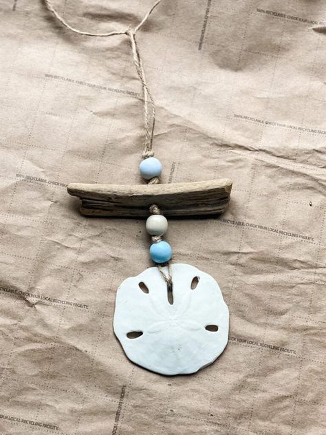 coastal ornament w sand dollar Sand Dollar Wall Decor, Sand Dollar Jewelry Diy, Sand Dollar Art Diy, Sand Dollar Craft Wall Decor, Sanddollar Ornaments Diy, Sand Dollar Display Ideas, Broken Sand Dollar Crafts, Sand Dollar Ornaments Diy, Sanddollar Crafts Diy Ideas